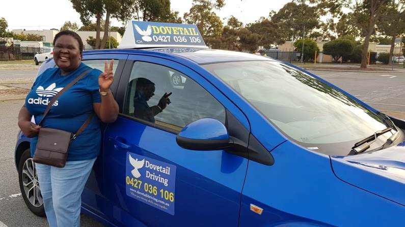 A student beside the blue Dovetail Driving car
