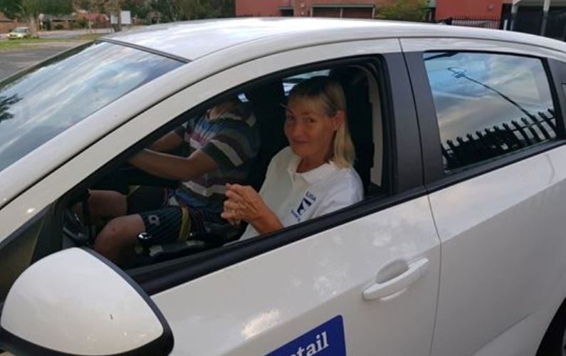 Lisa Archer in the white Dovetail Driving car with a student