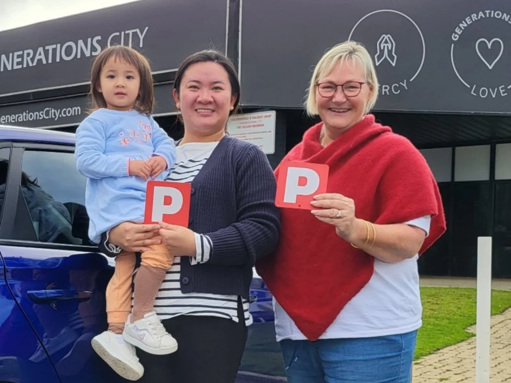 Lisa handing P-plates to a student who has just passed